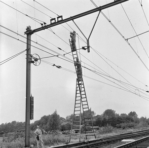 166470 Afbeelding van werkzaamheden aan de bovenleiding van het spoor te Lunetten bj Utrecht met behulp van een rolladder.